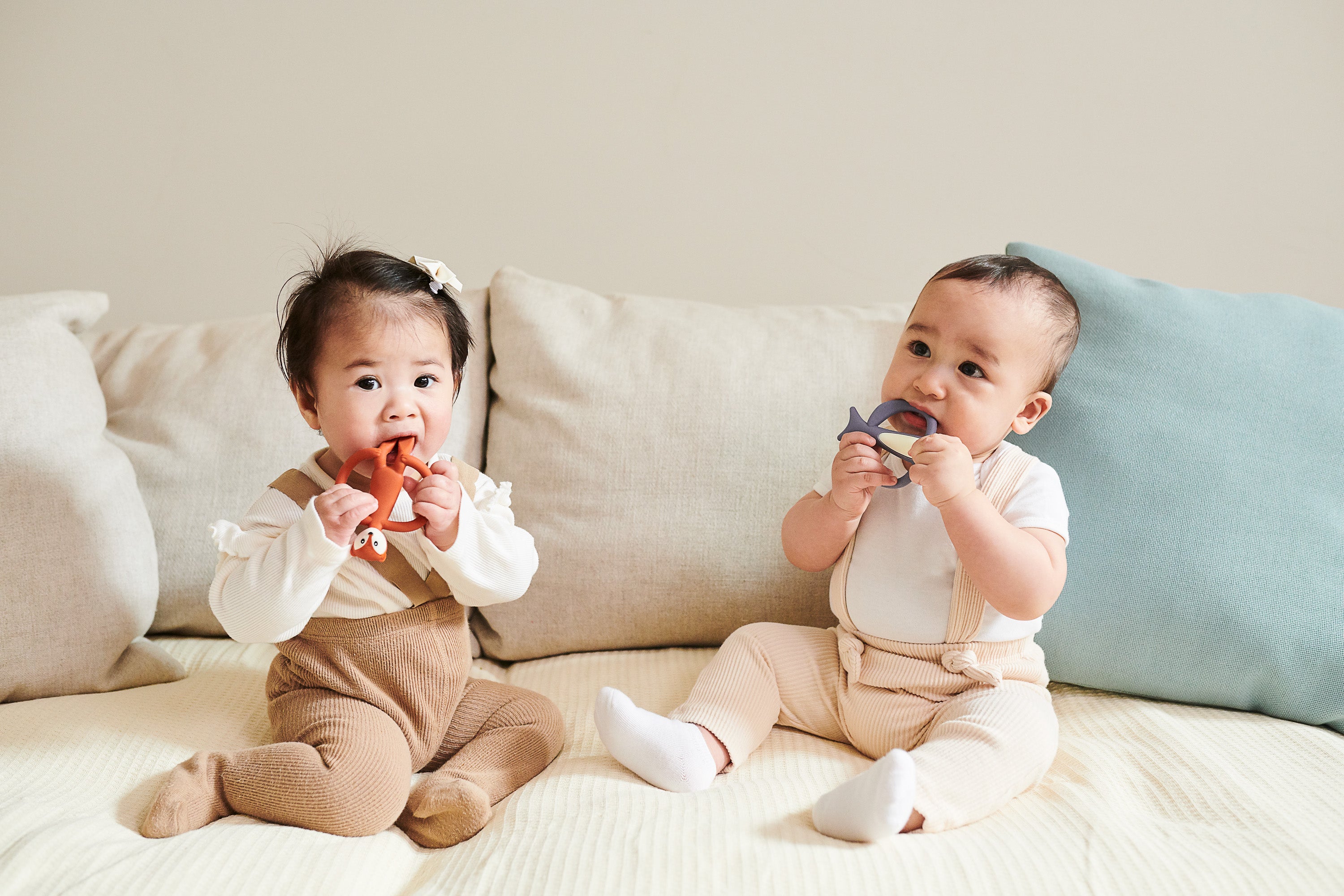 two babies with matchstick monkey teethers